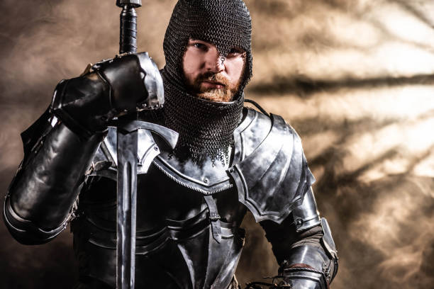 istock handsome knight in armor holding sword on black background 1185855404