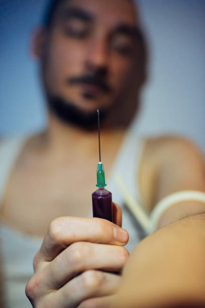 薬物中毒者はショットを撮る - injecting syringe spooky male ストックフォトと画像