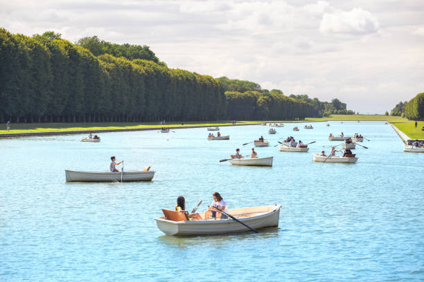 los turistas en barcos navegan a lo largo del gran canal en versalles - chateau de versailles fotografías e imágenes de stock