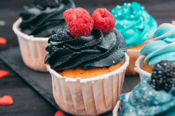 istock Set of different delicious cupcakes on dark 1185858943