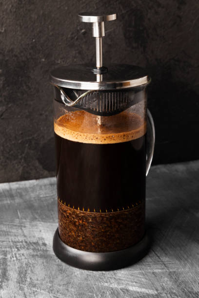 istock Coffee in french press on dark background 1185858992