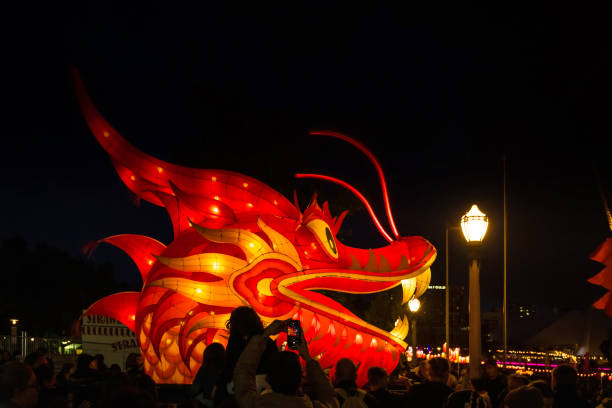 Adelaide, Australia - October 19, 2019: Hong Kong Dragon head carried through crowd of people  during Moon Lantern Festival celebration in Elder Park at night