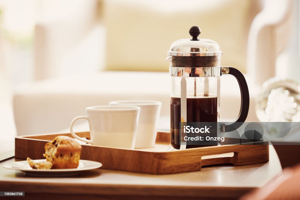 Fresh coffee and a french press Cup of fresh coffee and a french press on the tray with cupcake French Press Stock Photo