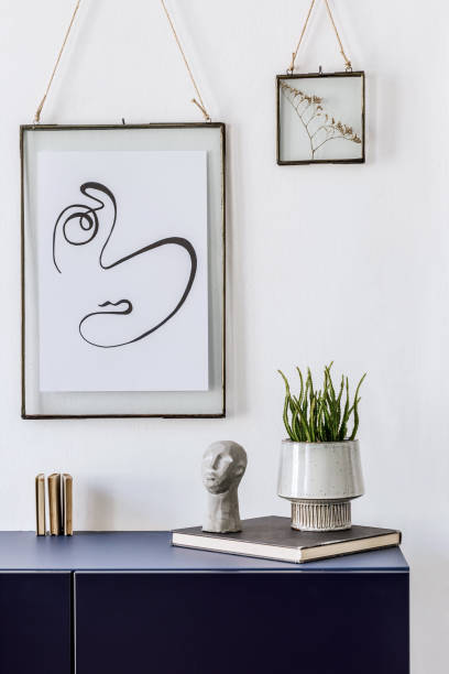 istock Stylish scandinavian living room with mock up poster frame, navy blue commode, table lamp and elegant accessories. Modern home decor. Interior design. Template Ready to use. 1185863038