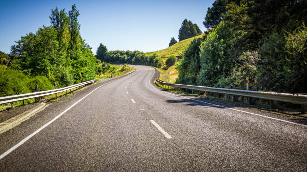 S-bend on a country road A road curving up a hill in rural New Zealand. north island new zealand stock pictures, royalty-free photos & images