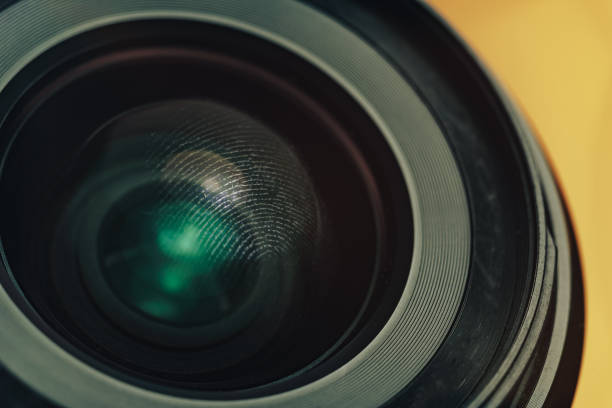 istock Close up beautiful black camera lens on a yellow background. Macro view.. 1185863181