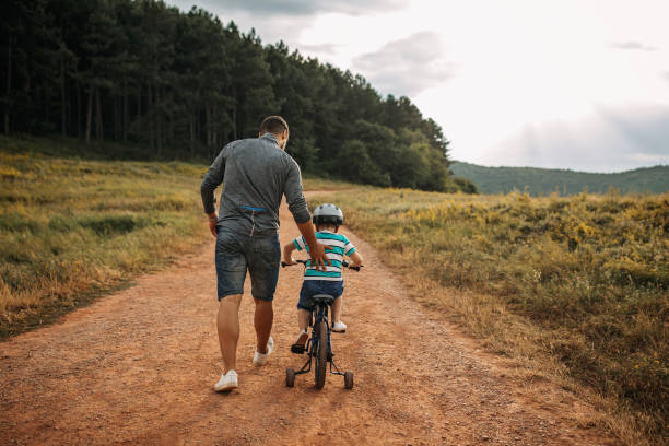 istock Father teaches son to ride a bike 1185864464