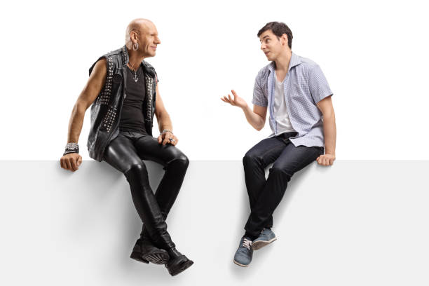 istock Young man talking to a punk in leather clotes and sitting on a panel 1185865926