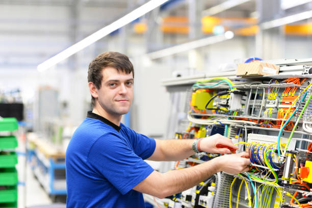 istock young operator assembles machine in a modern high tech factory - production of switch cabinets for industrial plant 1185867121