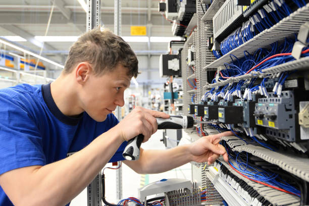 jeune opérateur assemble la machine dans une usine moderne de haute technologie - production des coffrets de commutateur pour l'usine industrielle - electronics photos et images de collection