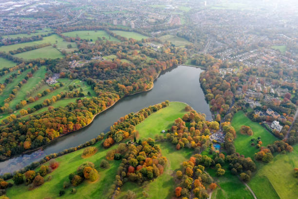 Aerial photo in autumn showing the beautiful autumn fall colours of a park in Leeds known as Roundhay Park in West Yorkshire UK, showing a typical British park and woods along side a lake. stock photo
