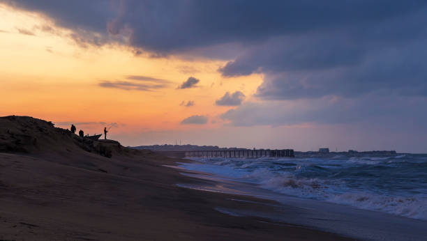 istock Fishermen catch fish on the seashore at sunset 1185870707