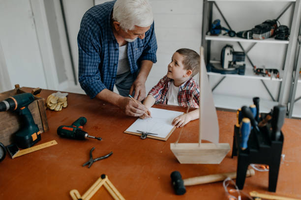 istock Grandfather and grandson building a ship 1185870862