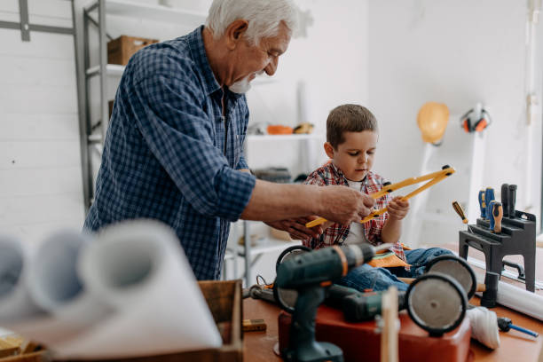 istock Grandfather and grandson building a ship 1185870947