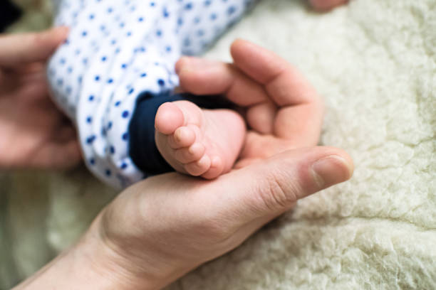 istock Little baby feet in dad's strong hand. 1185870954