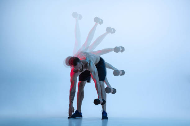 young caucasian bodybuilder training over blue background - shirtless energy action effort imagens e fotografias de stock