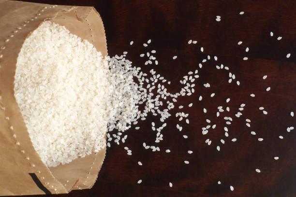 istock White rice on wood background 1185872978