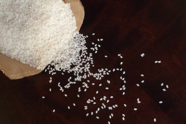 istock White rice on wood background 1185872981
