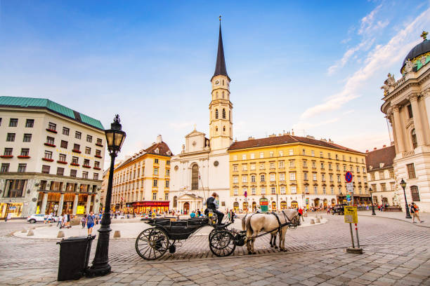 панорамный вид на церковь святого михаила на площади михаэлерплац с конных карет и туристов - михайловская площадь стоковые фото и изображения