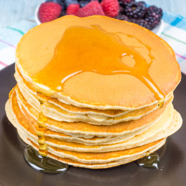 istock A stack of pancakes with berries and maple syrup close-up on a dark plate 1185877714