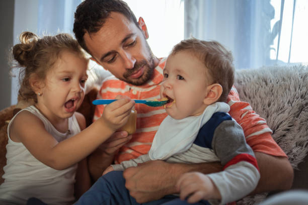istock Dad feeding his son with daughter 1185880958