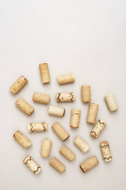 Minimal trendy concept with corks from wine bottles on lignt paper background with copy space. Flat lay for wine bar, winery, restaurant, wine list. Minimal trendy concept with corks from wine bottles on lignt paper background with copy space. Flat lay for wine bar, winery, restaurant, wine list. cork stopper stock pictures, royalty-free photos & images