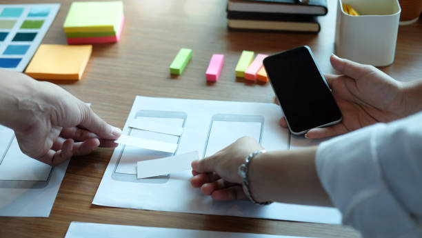 istock UX UI concept, Team of Website designer Creative planning application development draft sketch drawing template layout. 1185885311