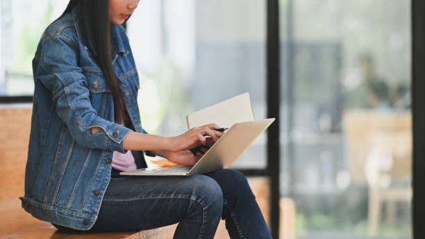 istock Cropped shot young female reading data in laptop computer with education center. 1185886053