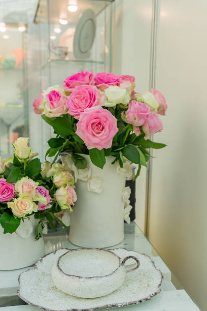 istock table serving decorated with blooming pink roses. Home cozy celebration or party 1185887620