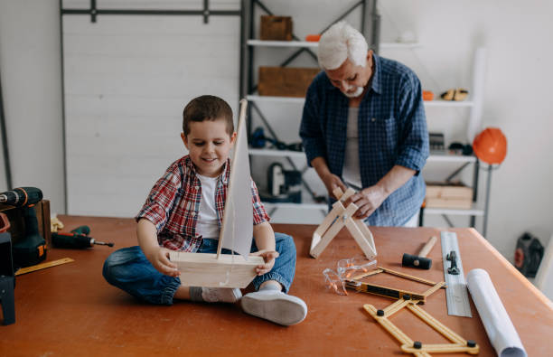 istock Grandfather and grandson building a ship 1185888356