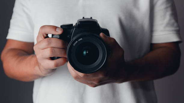 Photographer holding a digital camera Photographer holding a digital camera slr camera stock pictures, royalty-free photos & images
