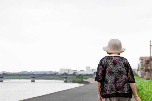 Japanese elderly person taking a walk by a river