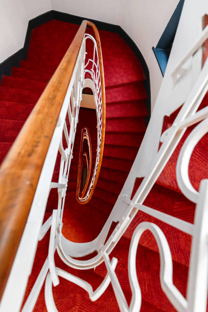 istock Spiral staircase with red carpet, vertical frame 1185897297