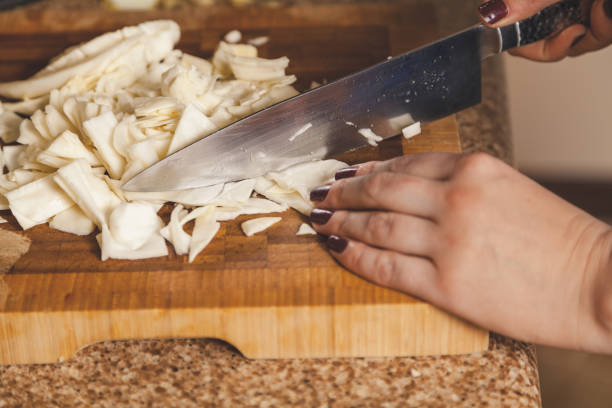 istock Female hands cut cabbage with knife on wooden board 1185897869