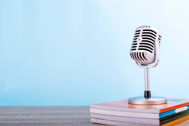 istock Education teaching concept : Retro microphone with many book put on wooden table isolated on blue background. 1185900357