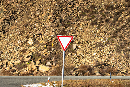 road sign give way on mountain road