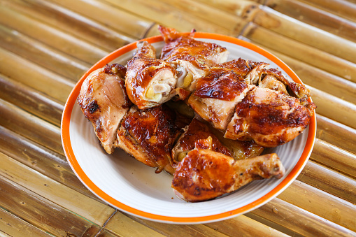 South East and East Asia: Typical Asian Food. Grilled chicken. Grilled BBQ Chicken. Barbecued chicken on bamboo table background. Street food Asian