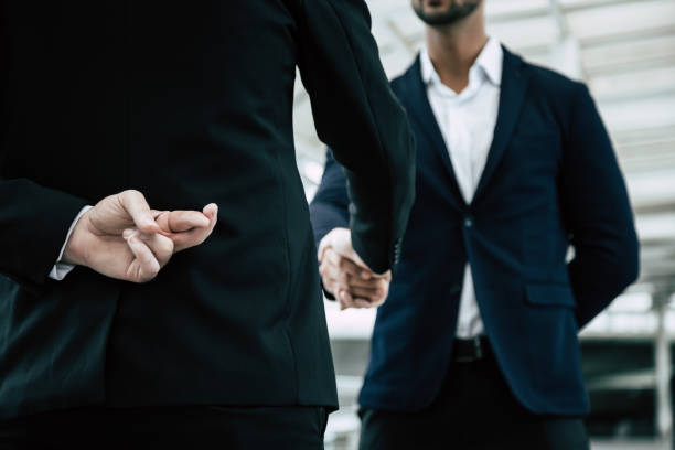 Businessman or politician cross finger, hiding behind his back during he get handshake to another person, businessman. Businessman pretend to be good person, he is liar. White collar worker is fraud Businessman or politician cross finger, hiding behind his back during he get handshake to another person, businessman. Businessman pretend to be good person, he is liar. White collar worker is fraud bluff stock pictures, royalty-free photos & images