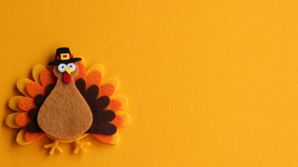 decorated felt turkey on an orange festive background with writing space