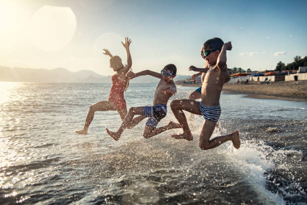 Senior man jumping with grandchildren into sea Little boys playing with their grandfather in the sea. The grandfather is holding two boys on hands. Sunny summer day.
Nikon D850 wave jumping stock pictures, royalty-free photos & images