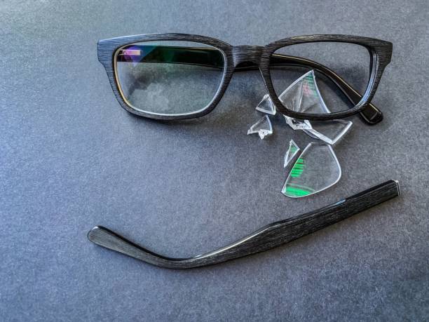 istock plastic glasses with a broken lens and a torn earhook on a dark background. 1185906845