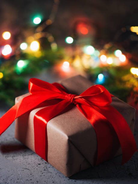 istock Gift box with red ribbon on table night holiday background 1185907750