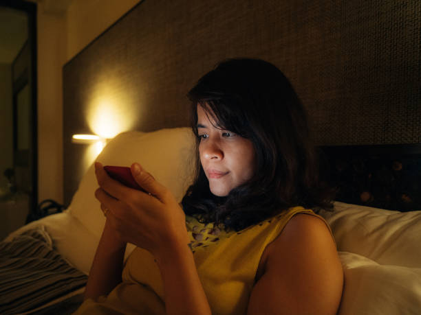 istock Asian woman using smart phone late in night. 1185908242