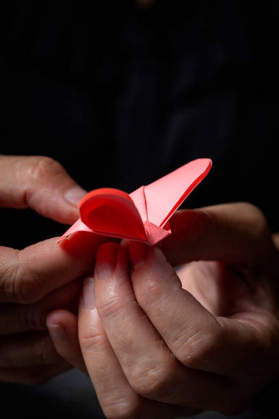 istock Woman's hands holding an origami figure 1185908325