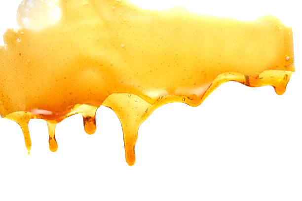 istock Sweet honey flowing on white background 1185911854
