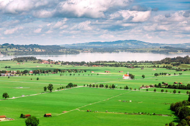 vista aérea do pasto verde do campo e do lago de forggensee perto de schwangau, alemanha - st colomans church - fotografias e filmes do acervo