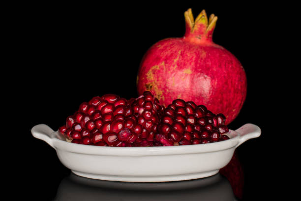 istock Fresh red pomergranate isolated on black glass 1185913741