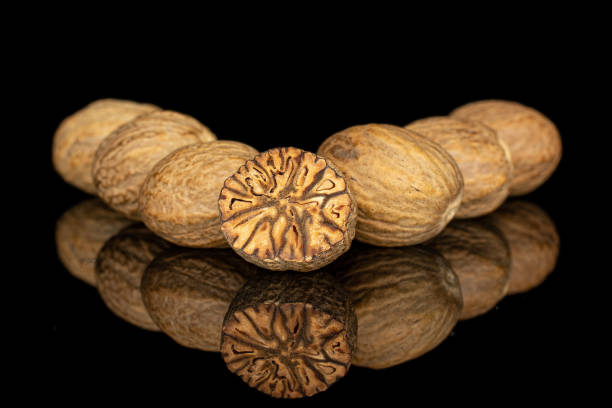 istock Dry brown nutmeg isolated on black glass 1185914773