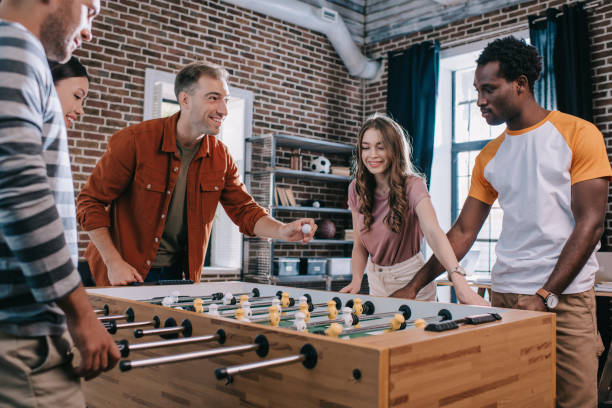 istock cheerful multicultural businesspeople playing table soccer in office 1185916934
