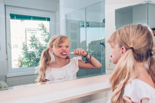 istock little child brushing teeth in the bathroom 1185918433